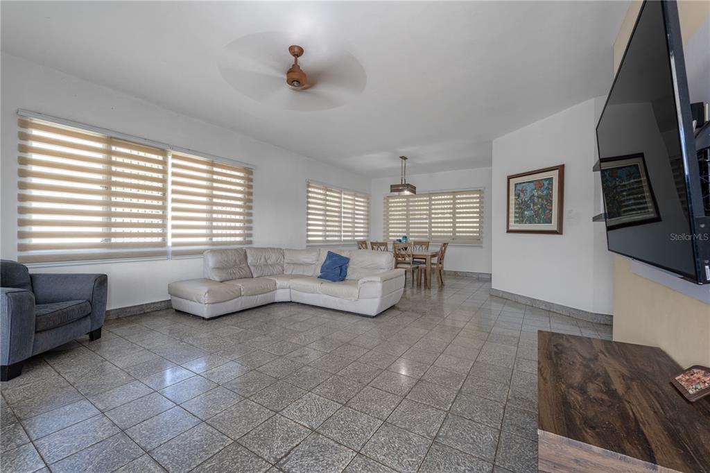 A living and dining area features tile flooring, a white sectional sofa, and window blinds — 69 Urbanizacion Ramirez SAGRADO CORAZON ST UNIT 69, CABO ROJO, PR