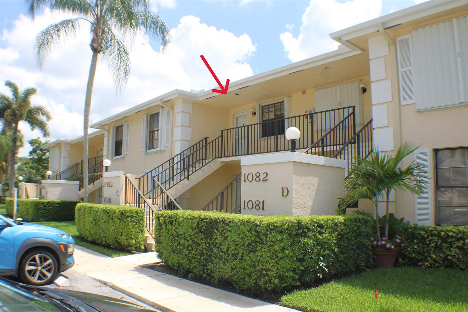 Exterior view of a two-story apartment building with stairs leading to a second-floor unit — 1082 Keystone Drive # C, Jupiter FL 33458, JUPITER, FL