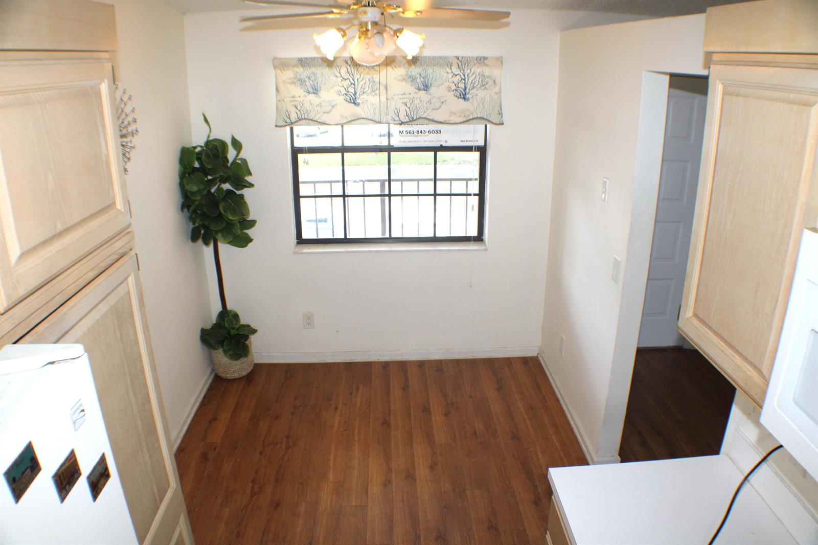 A small dining area features wood-look flooring, a window with a valance, and a ceiling fan — 1082 Keystone Drive # C, Jupiter FL 33458, JUPITER, FL