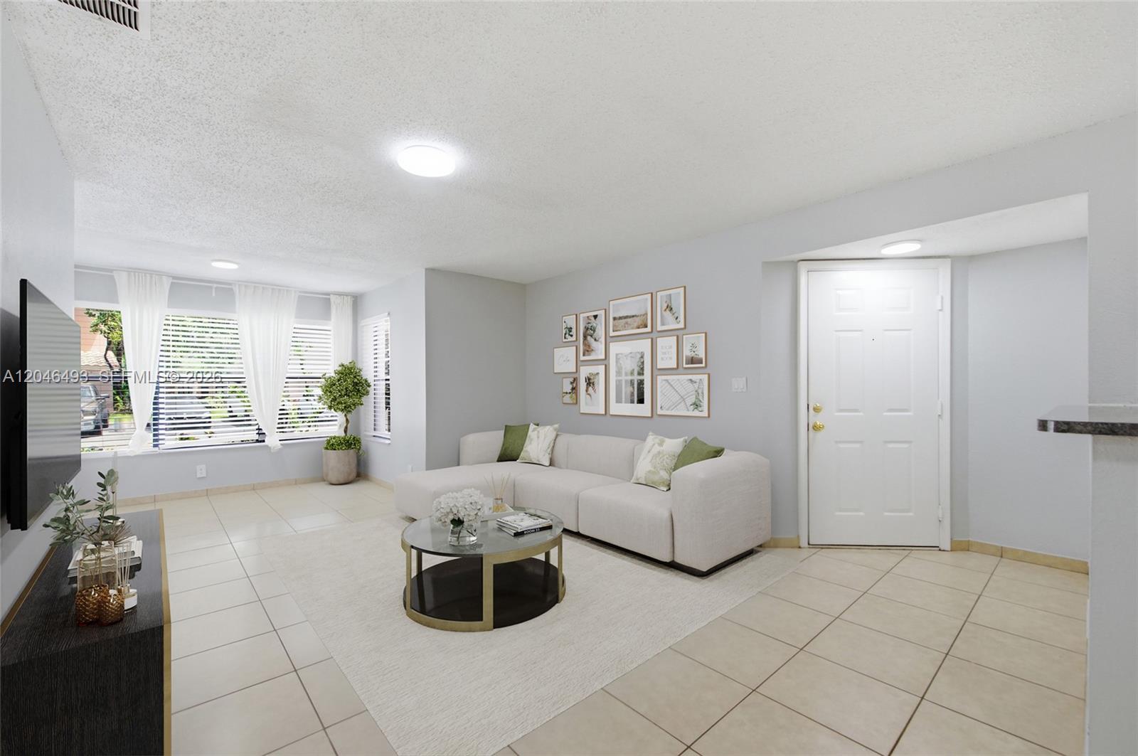A living room features a white sectional sofa, a glass coffee table, and tile flooring — 2846 S University Dr # 4104, Davie FL 33328, DAVIE, FL