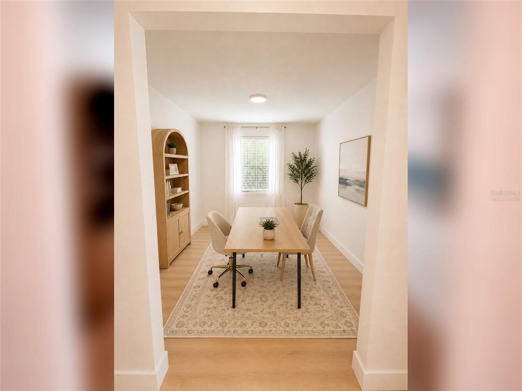 A home office features a wooden desk, two chairs, a bookshelf, and a patterned area rug — 14048 LARKSPUR LAKE DRIVE, WINTER GARDEN, FL