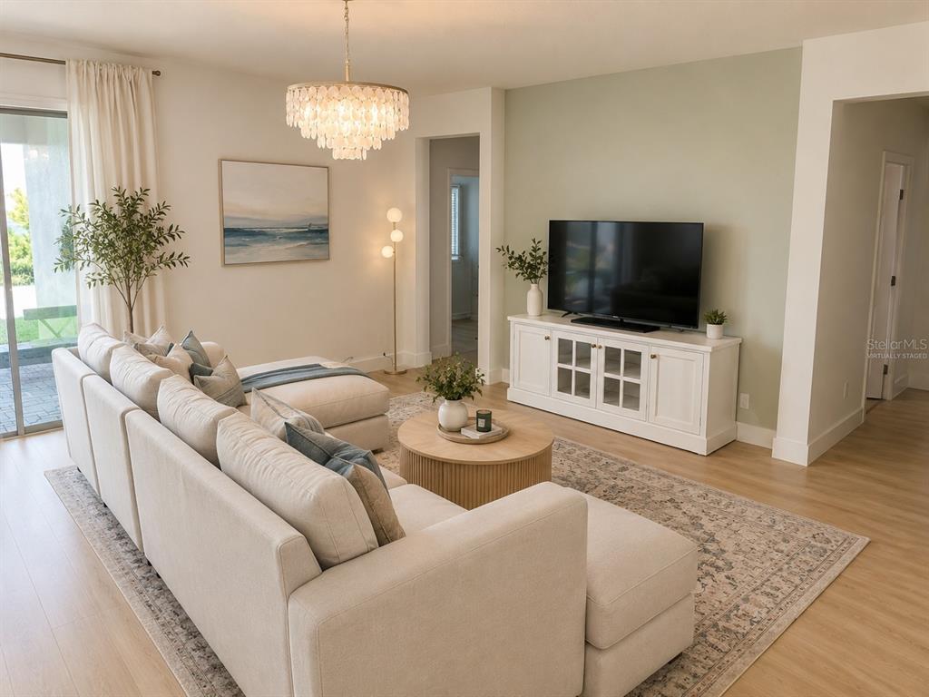 A living room features a sectional sofa, a television on a white console, and chandelier lighting — 14048 LARKSPUR LAKE DRIVE, WINTER GARDEN, FL