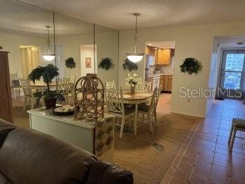 A dining area features a round table, chairs, and a mirrored wall reflecting the kitchen — 3124 LAKE BAYSHORE DRIVE UNIT 219, BRADENTON, FL