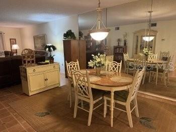 A dining room features a wooden table, six chairs, a sideboard, and a large wall mirror — 3124 LAKE BAYSHORE DRIVE UNIT 219, BRADENTON, FL