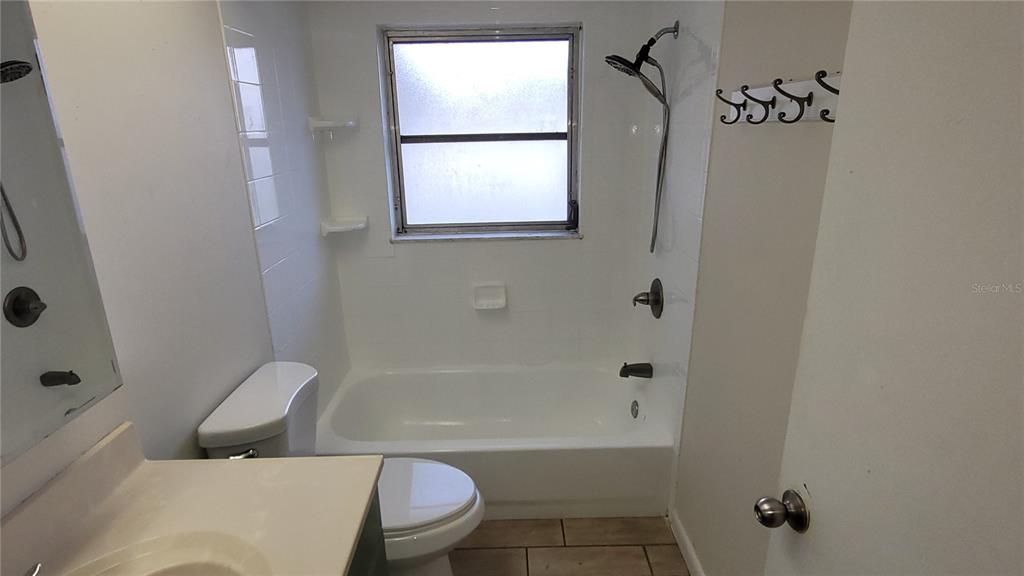 A bathroom features a vanity, toilet, and a bathtub with a shower head — 9 NEW YORK BOULEVARD, BEVERLY HILLS, FL