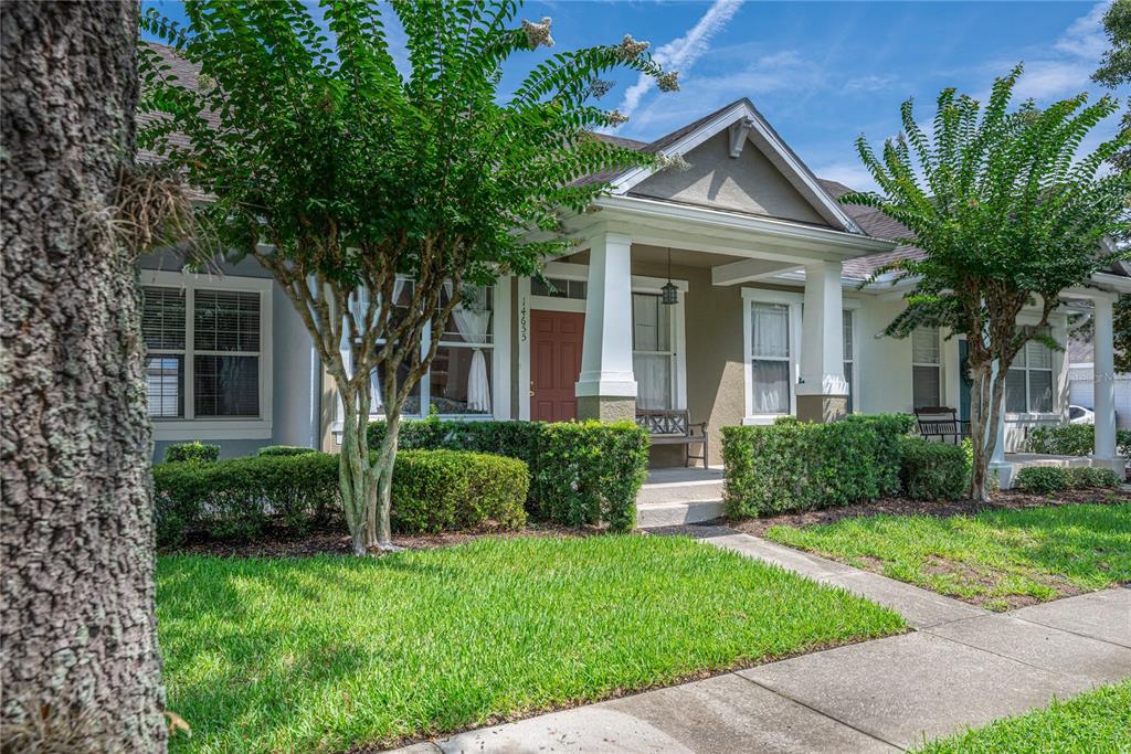 A single-story house with a red front door, a covered porch, and manicured landscaping — 14655 WATER LOCUST DRIVE, ORLANDO, FL