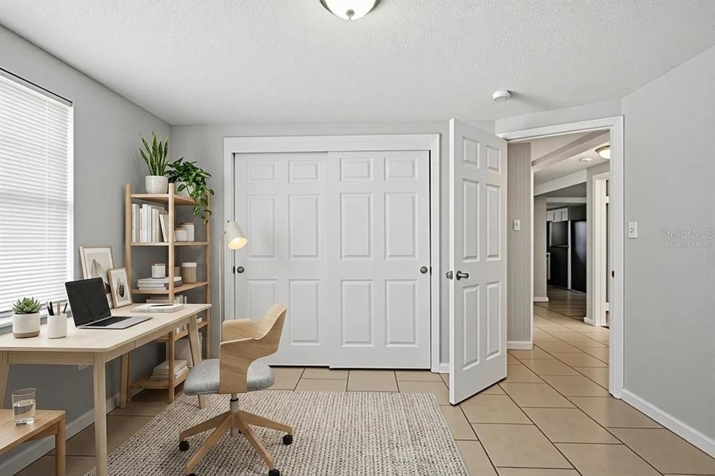 A home office features a desk, shelving, a chair, and tile flooring near a closet — 4506 POOLE STREET, NEW PORT RICHEY, FL