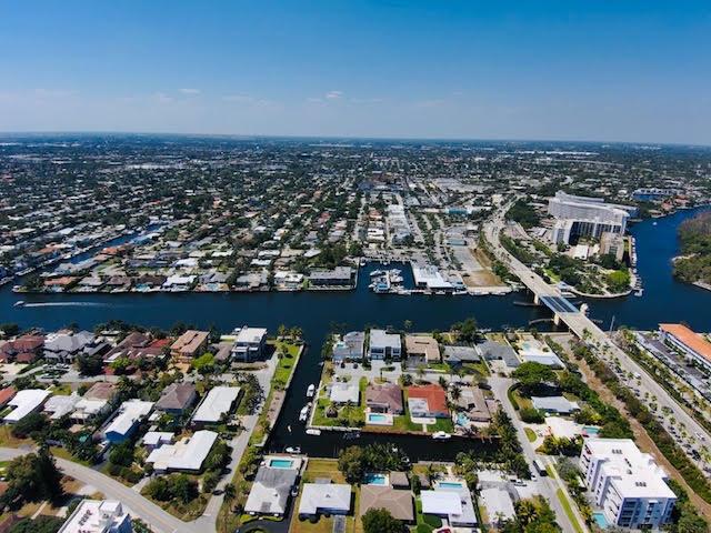 This aerial view shows a residential neighborhood with canals, a bridge, and waterfront properties — 120 S Ocean Drive, Deerfield Beach FL 33441, DEERFIELD BEACH, FL
