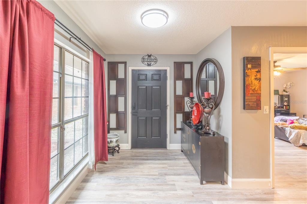 A single-story brick house features a concrete driveway, a palm tree, and outdoor seating — 2550 SE 40TH STREET, OCALA, FL
