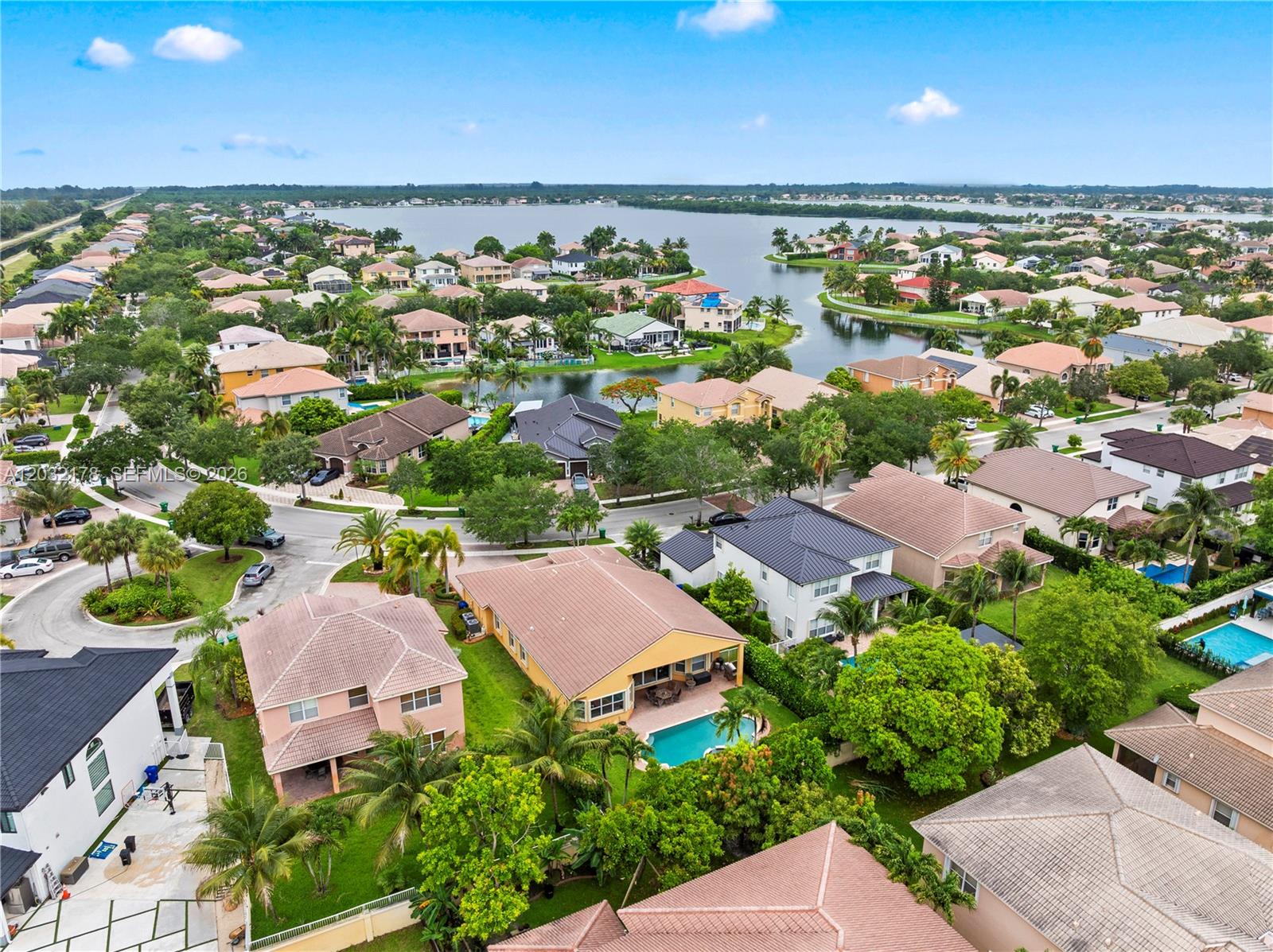 An aerial view shows a suburban neighborhood with houses, swimming pools, and a large lake — 5431 SW 184th Way, Miramar FL 33029, MIRAMAR, FL