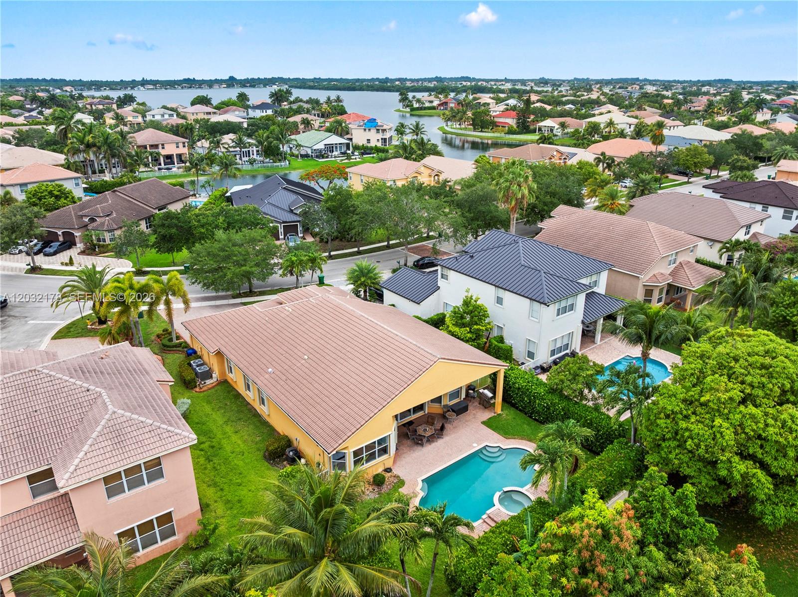 An aerial view shows a yellow house with a pool and patio in a neighborhood — 5431 SW 184th Way, Miramar FL 33029, MIRAMAR, FL