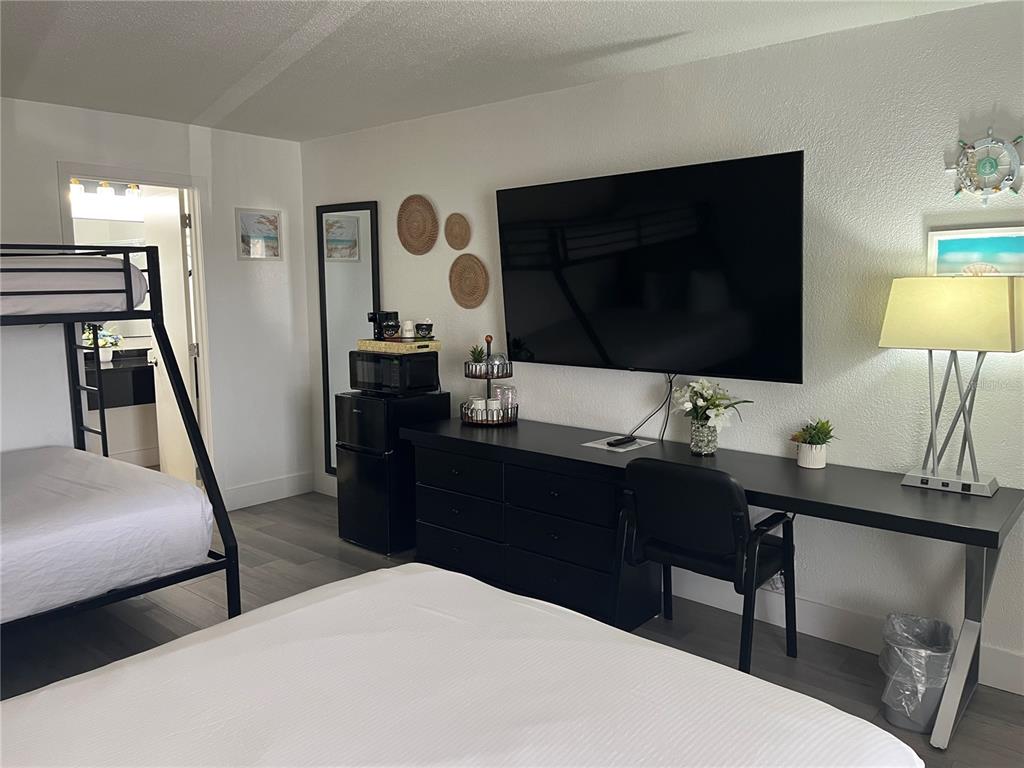 A bedroom features a bunk bed, a desk with a television, and a small refrigerator — 7150 N TAMIAMI TRAIL UNIT S510, SARASOTA, FL
