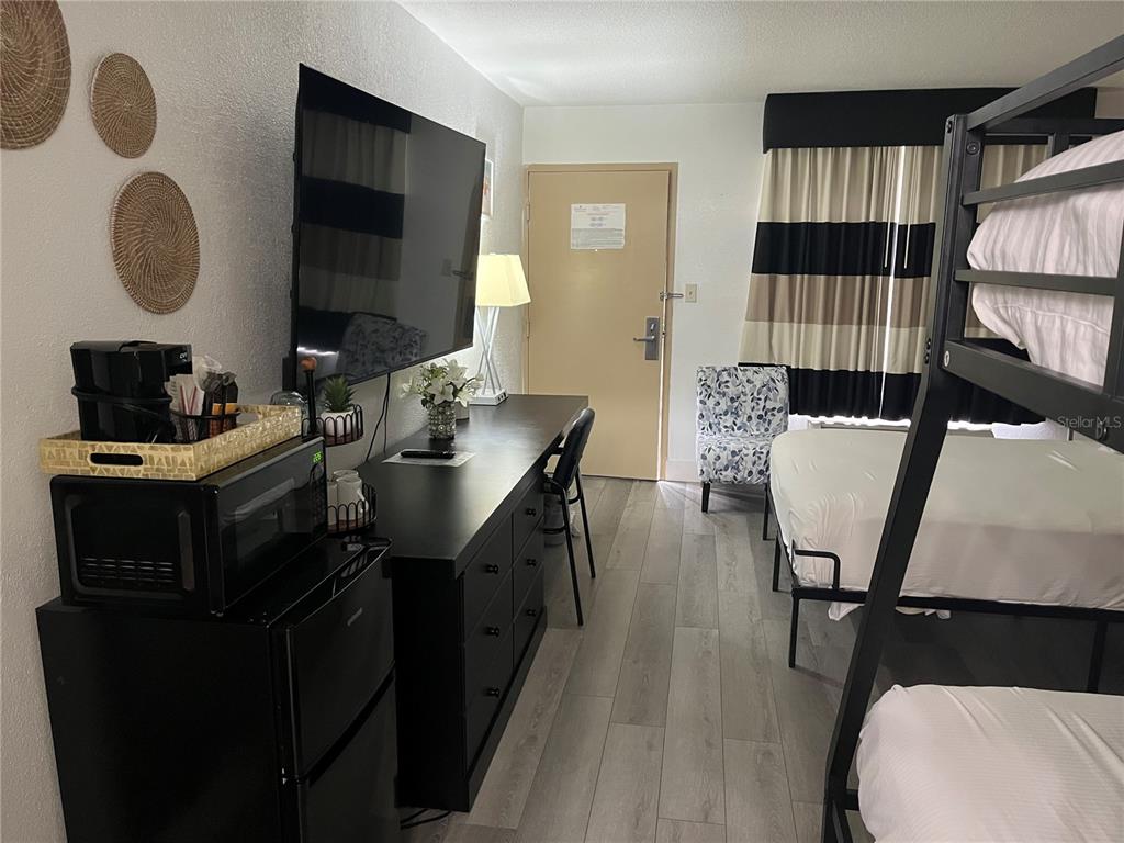 A hotel room features a bunk bed, a television, a desk, and a small refrigerator — 7150 N TAMIAMI TRAIL UNIT S510, SARASOTA, FL