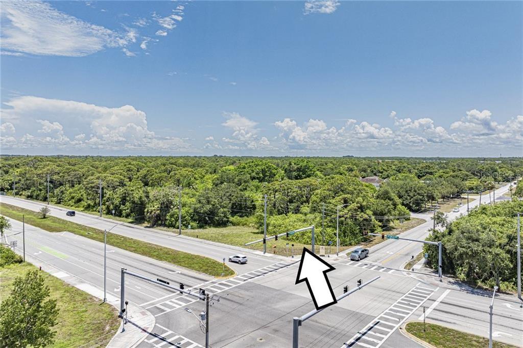 An aerial view shows a vacant, wooded corner lot at a paved road intersection — 2551 ST LUCIE BOULEVARD, FORT PIERCE, FL