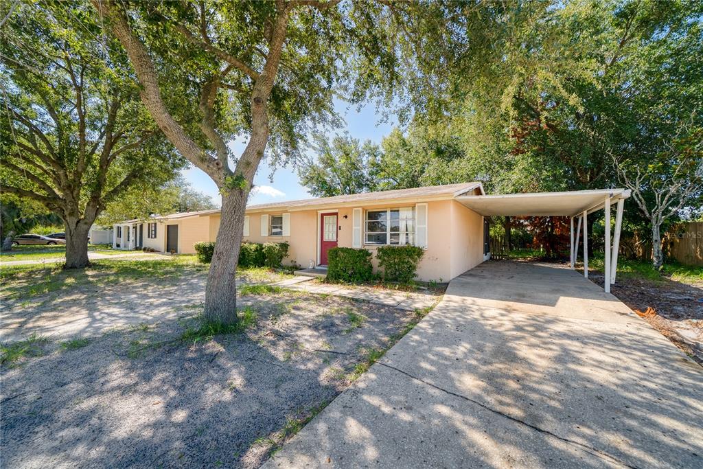 A single-story house with a peach exterior, a red front door, and an attached carport — 2913 KEESLER STREET, DELTONA, FL