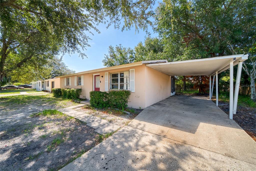 A single-story house with a peach exterior, a red front door, and an attached carport — 2913 KEESLER STREET, DELTONA, FL