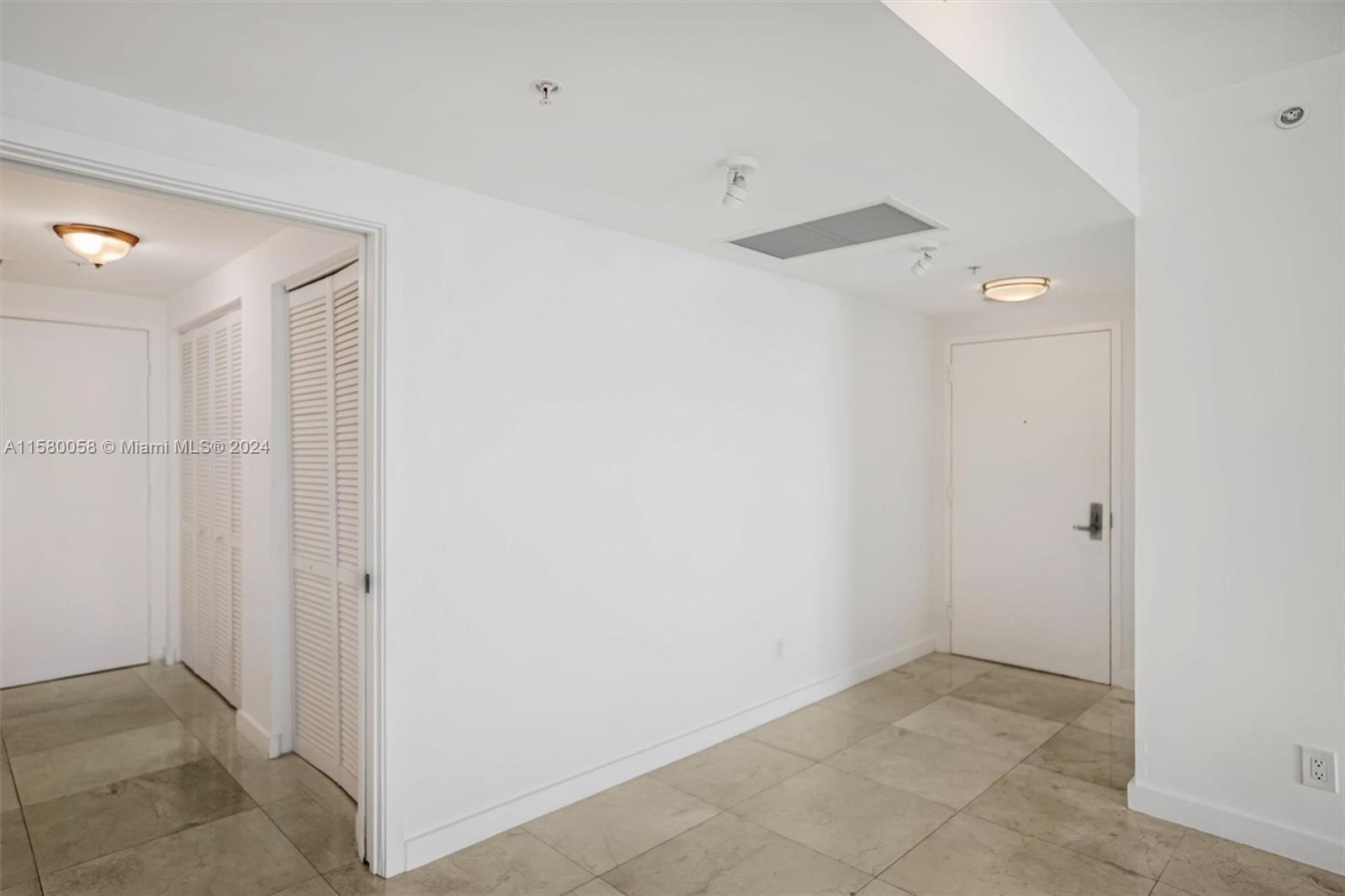 A bright entryway features white walls, tiled flooring, several doors, and ceiling-mounted light fixtures — 325 NE Biscayne Blvd # 1923, Miami FL 33131, MIAMI, FL