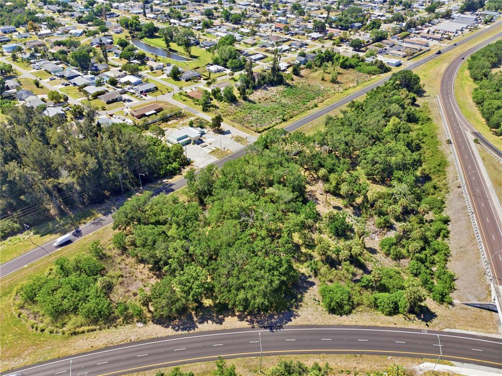 An aerial view shows a wooded lot situated between two roads and a residential neighborhood — 4340 US 19, PALMETTO, FL