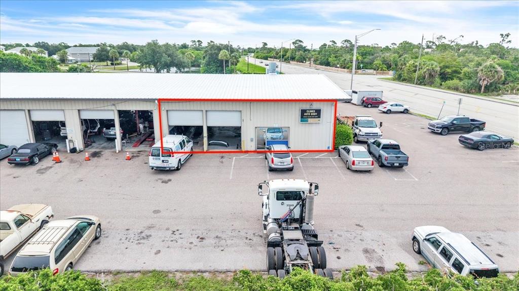 An aerial view shows a commercial building with multiple garage bays and a parking lot — 23415 JANICE AVENUE UNIT 22,23, PUNTA GORDA, FL