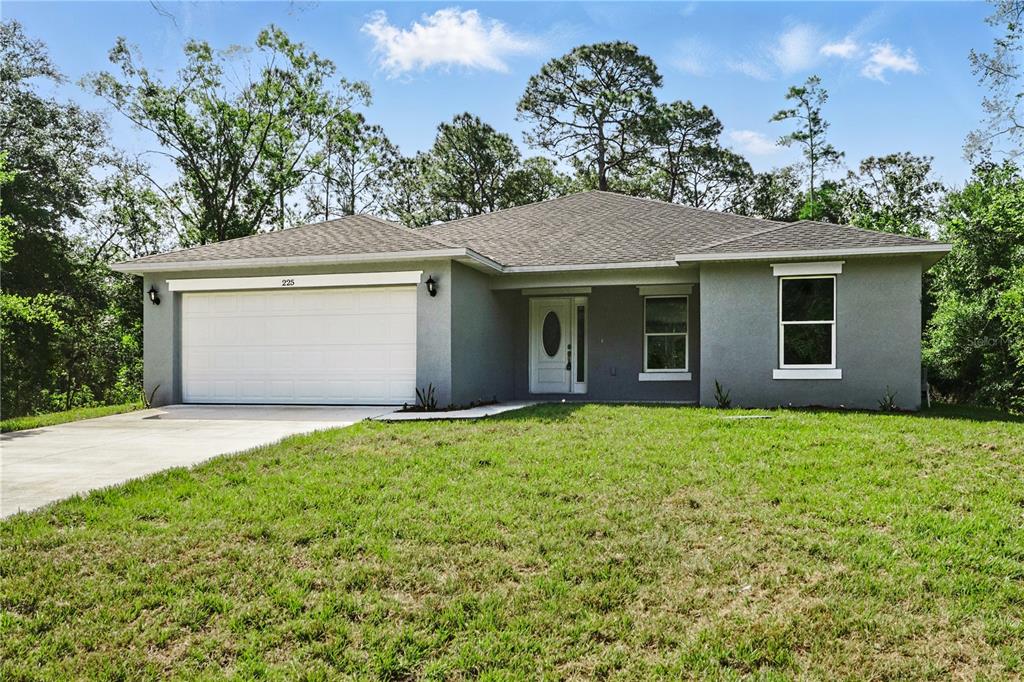 A single-story gray house with a two-car garage and a front entrance sits on grass — 225 STARLING COURT, KISSIMMEE, FL