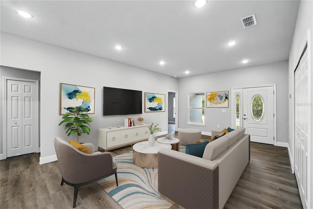 A living room features a television, sofa, armchair, coffee tables, and light-colored wood flooring — 225 STARLING COURT, KISSIMMEE, FL