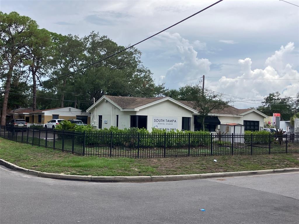 A single-story dental office building with a black metal fence sits on a corner lot — 4306 W KENSINGTON AVENUE, TAMPA, FL