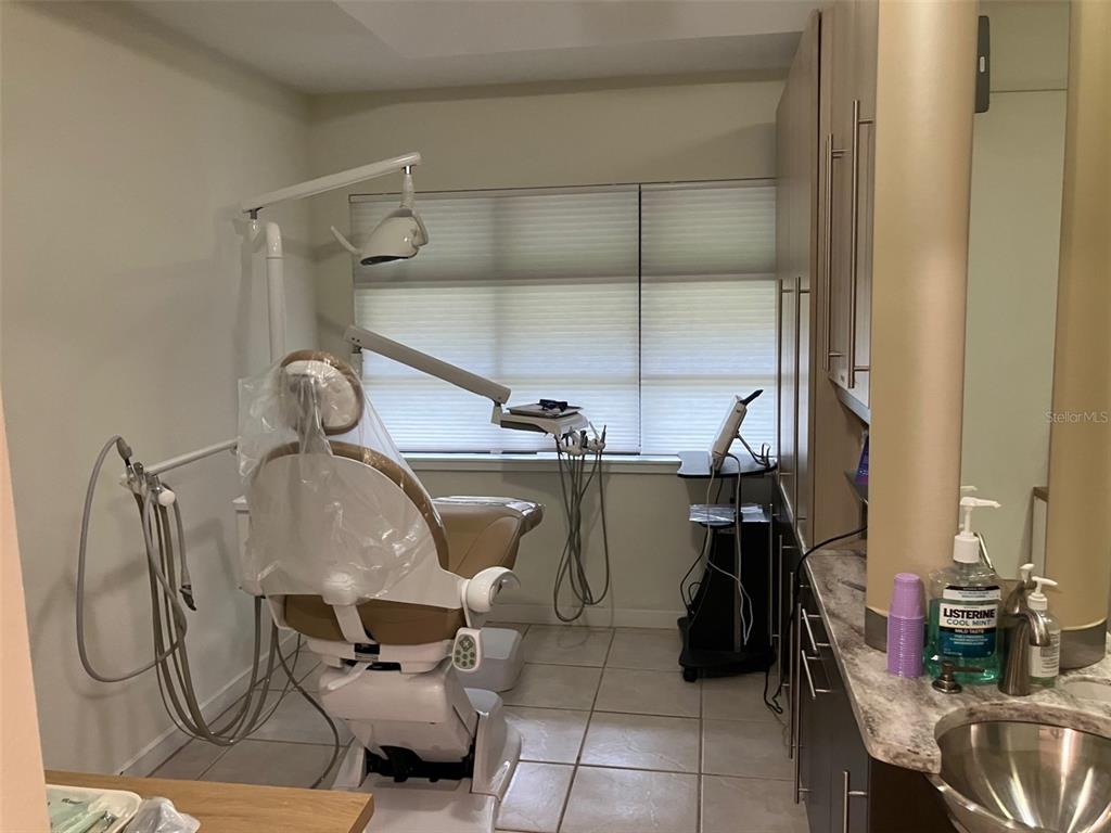 A dental examination room features a patient chair, medical equipment, cabinetry, and a sink — 4306 W KENSINGTON AVENUE, TAMPA, FL