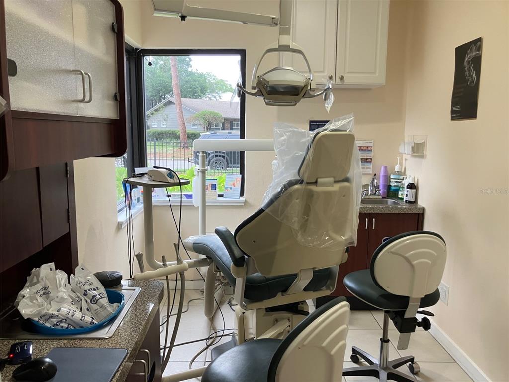 A dental exam room features a patient chair, medical equipment, a sink, and a large window — 4306 W KENSINGTON AVENUE, TAMPA, FL