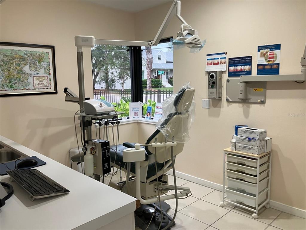 A dental exam room features a patient chair, medical equipment, a computer, and a window — 4306 W KENSINGTON AVENUE, TAMPA, FL