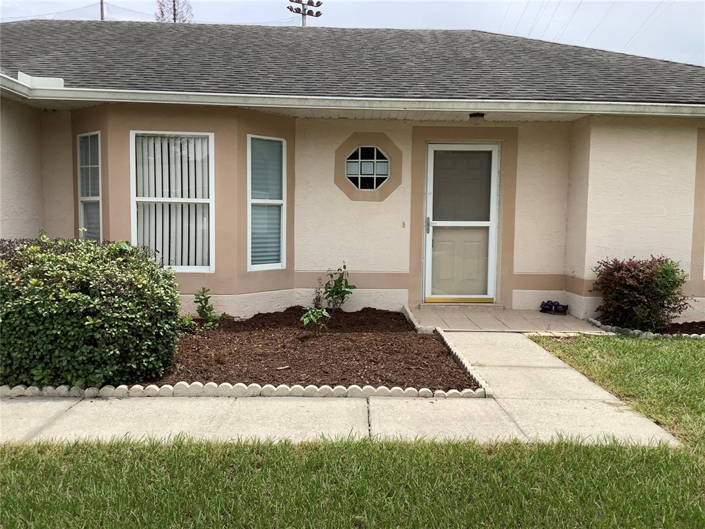 The exterior of a single-story house features a bay window, a front door, and landscaping — 665 STEVELYNN CIRCLE, WINTER GARDEN, FL