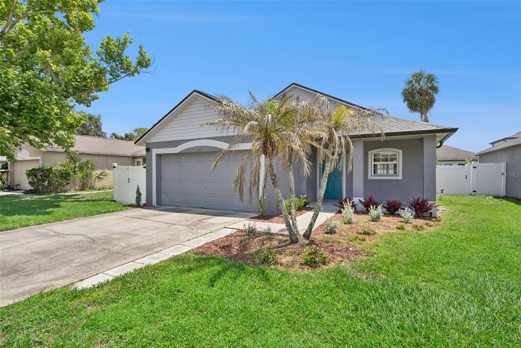 A single-story house with a gray exterior, a two-car garage, and a palm tree out front — 1189 AMANDA KAY CIRCLE, SANFORD, FL