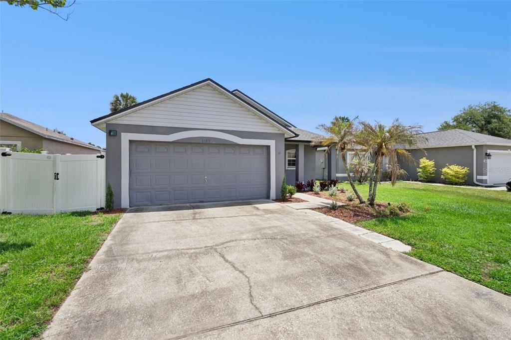A single-story house with a gray garage, white siding, and a concrete driveway — 1189 AMANDA KAY CIRCLE, SANFORD, FL
