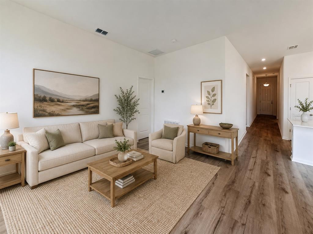 A living room features a beige sofa, armchair, wooden coffee table, and light wood flooring — 6213 SANDERS GROVE CIRCLE, OKAHUMPKA, FL
