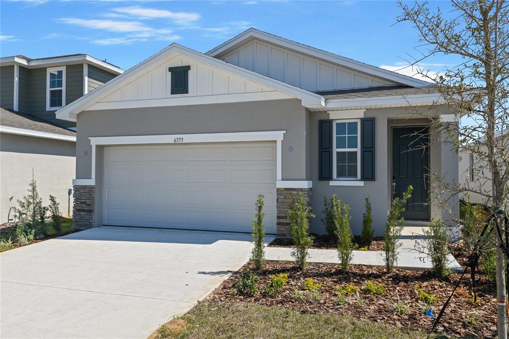 A single-story house with a gray stucco exterior, a two-car garage, and a front walkway — 6373 CLOVER STREET, LAKE HAMILTON, FL