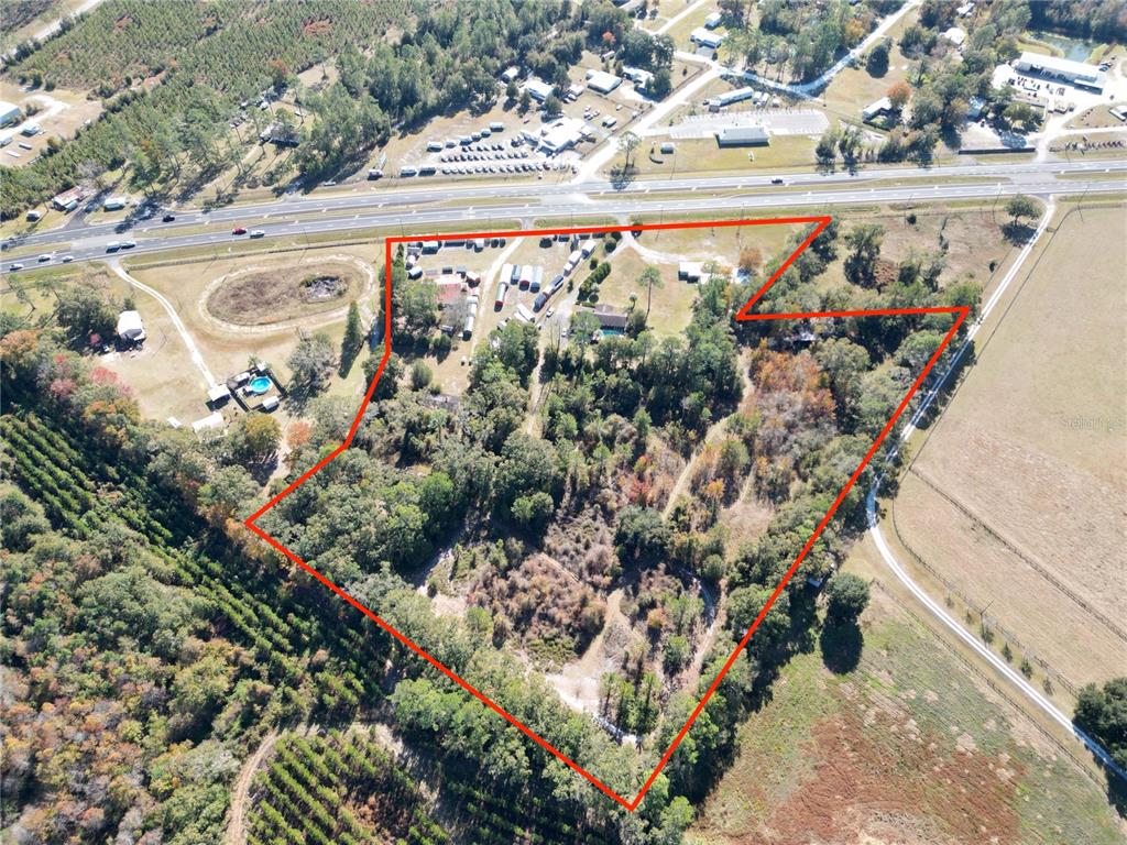 An aerial view shows a wooded property outlined in red next to a highway — 11782 SW 59TH AVENUE, STARKE, FL