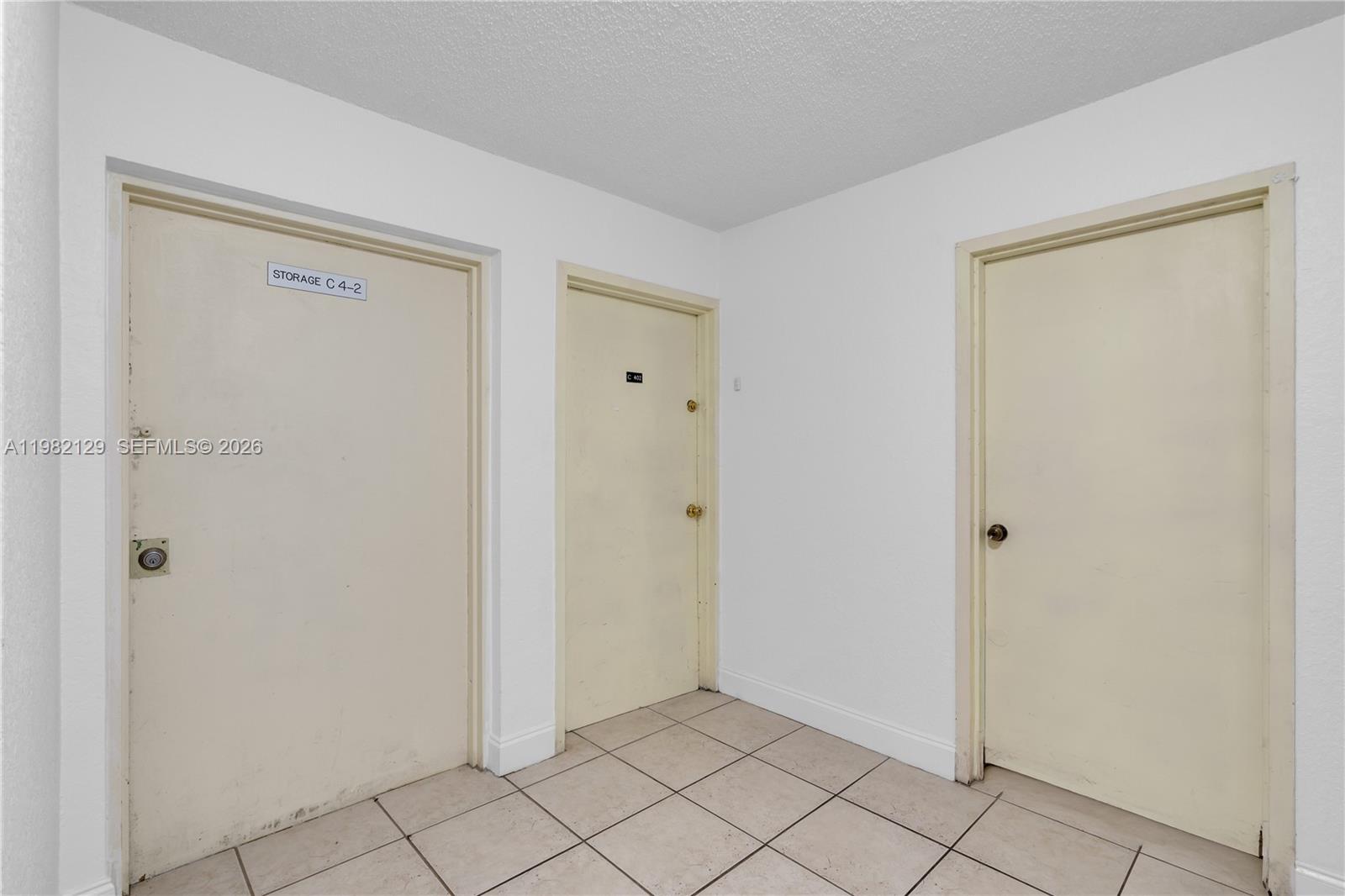 A small tiled hallway features three plain doors, including one labeled for storage — 9001 SW 77th Ave # C402, Miami FL 33156, MIAMI, FL