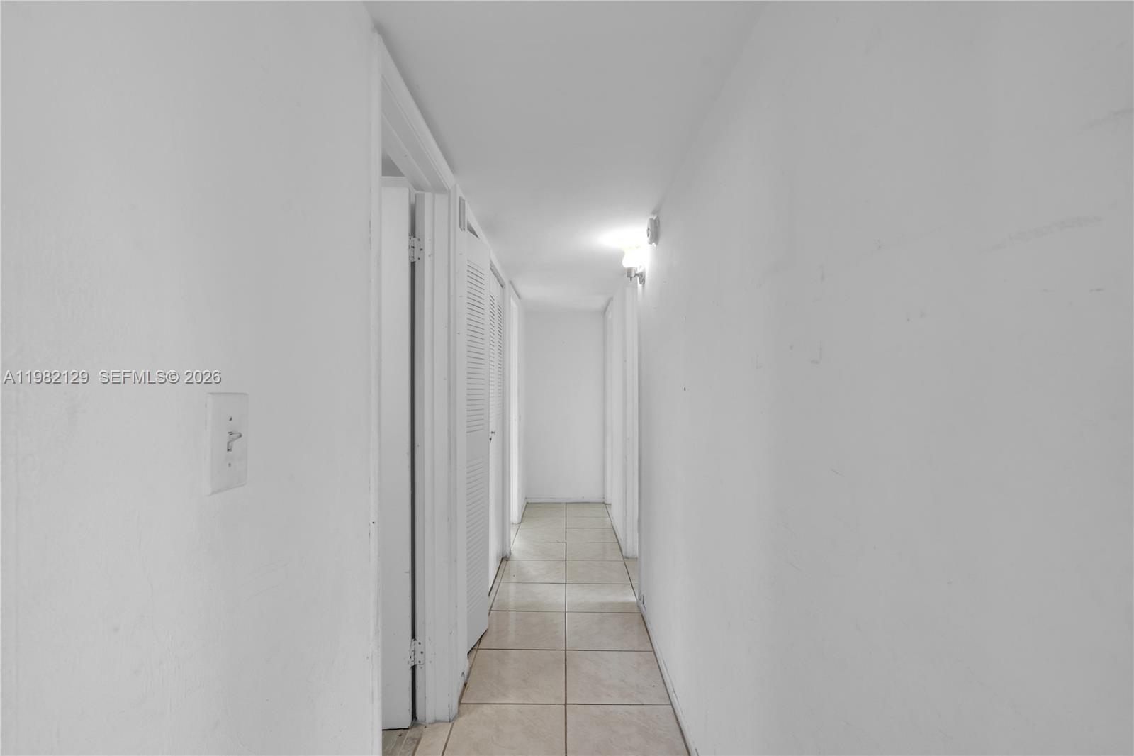A narrow hallway features white walls, tiled flooring, and several white louvered closet doors — 9001 SW 77th Ave # C402, Miami FL 33156, MIAMI, FL