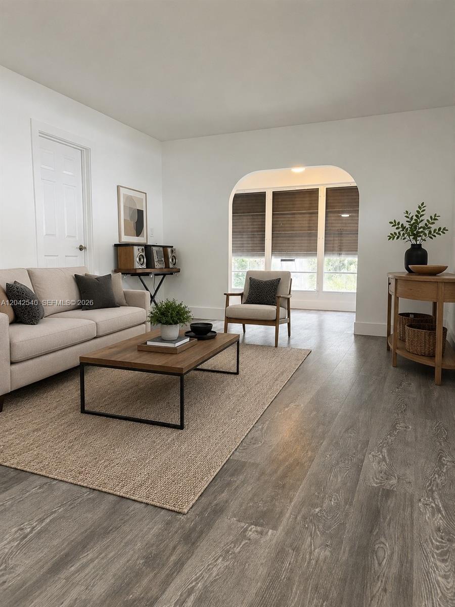 A living room features a beige sofa, wooden coffee table, and an arched entryway — 1951 NE 39th St # 138, Lighthouse Point FL 33064, LIGHTHOUSE POINT, FL