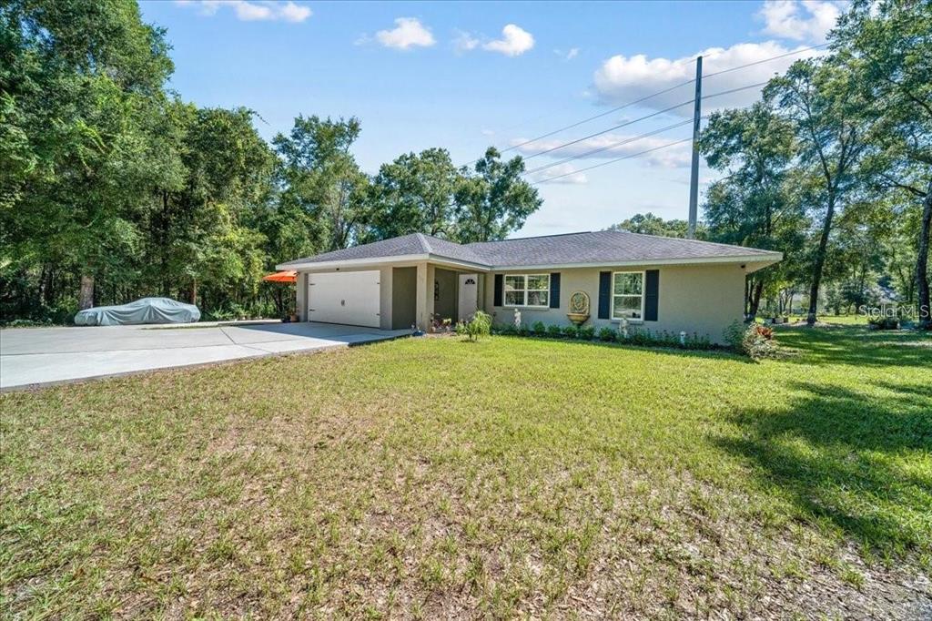A single-story house with a beige exterior, a two-car garage, and a large front lawn — 543 N ROOKS AVENUE, INVERNESS, FL