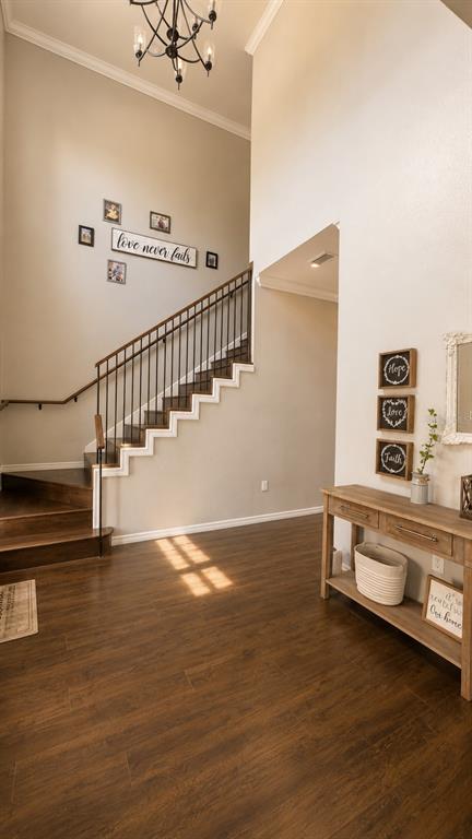 An entryway features dark wood flooring, a staircase with iron railings, and a console table — 14831 SE 1ST PLACE, WILLISTON, FL
