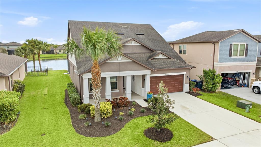 A two-story house with a brown roof, a palm tree, and a two-car garage — 6224 KEVESTA AVENUE, PALMETTO, FL