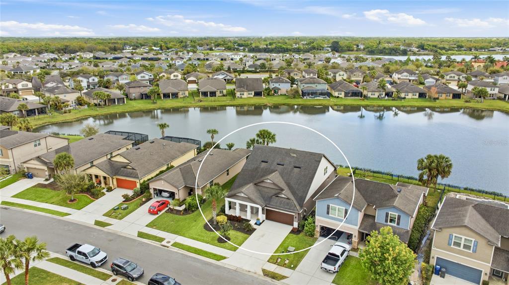 An aerial view shows a suburban house with a dark roof beside a lake — 6224 KEVESTA AVENUE, PALMETTO, FL
