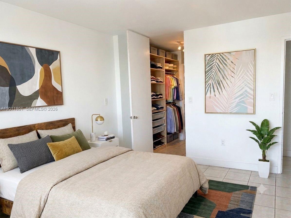 A bedroom features a bed, a walk-in closet with shelving, and two framed wall art pieces — 150 SE 25th Rd # 8i, Miami FL 33129, MIAMI, FL