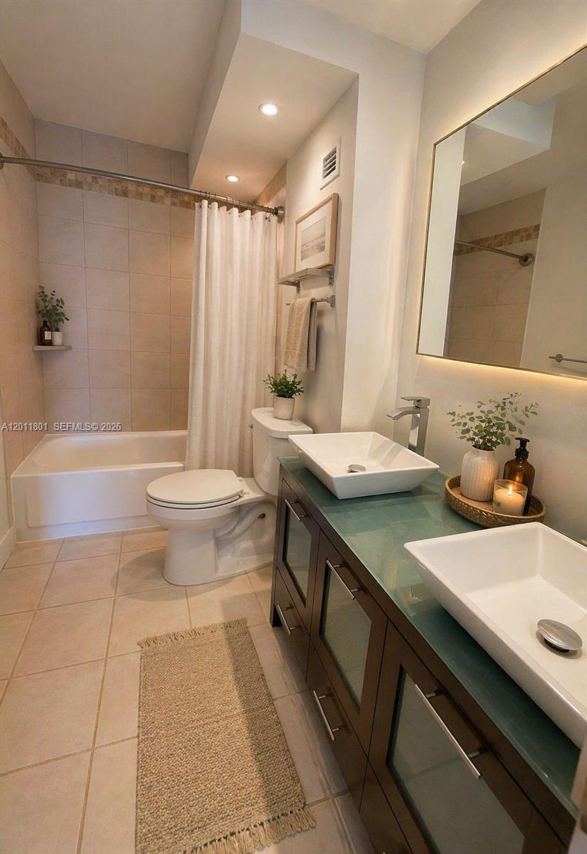 A bathroom features a glass-topped double vanity, vessel sinks, a toilet, and a shower-tub combo — 150 SE 25th Rd # 8i, Miami FL 33129, MIAMI, FL