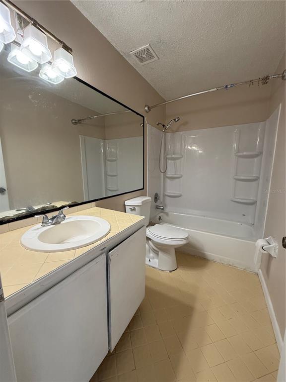 A bathroom features a white vanity, a large mirror, a toilet, and a shower-tub combo — 1619 S HIGH STREET, DELAND, FL
