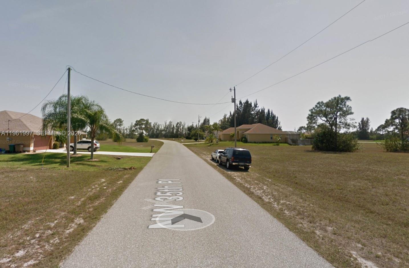 A paved residential street with houses and parked cars on a sunny day — 2336 NW 35TH PL, Cape Coral FL 33993, CAPE CORAL, FL