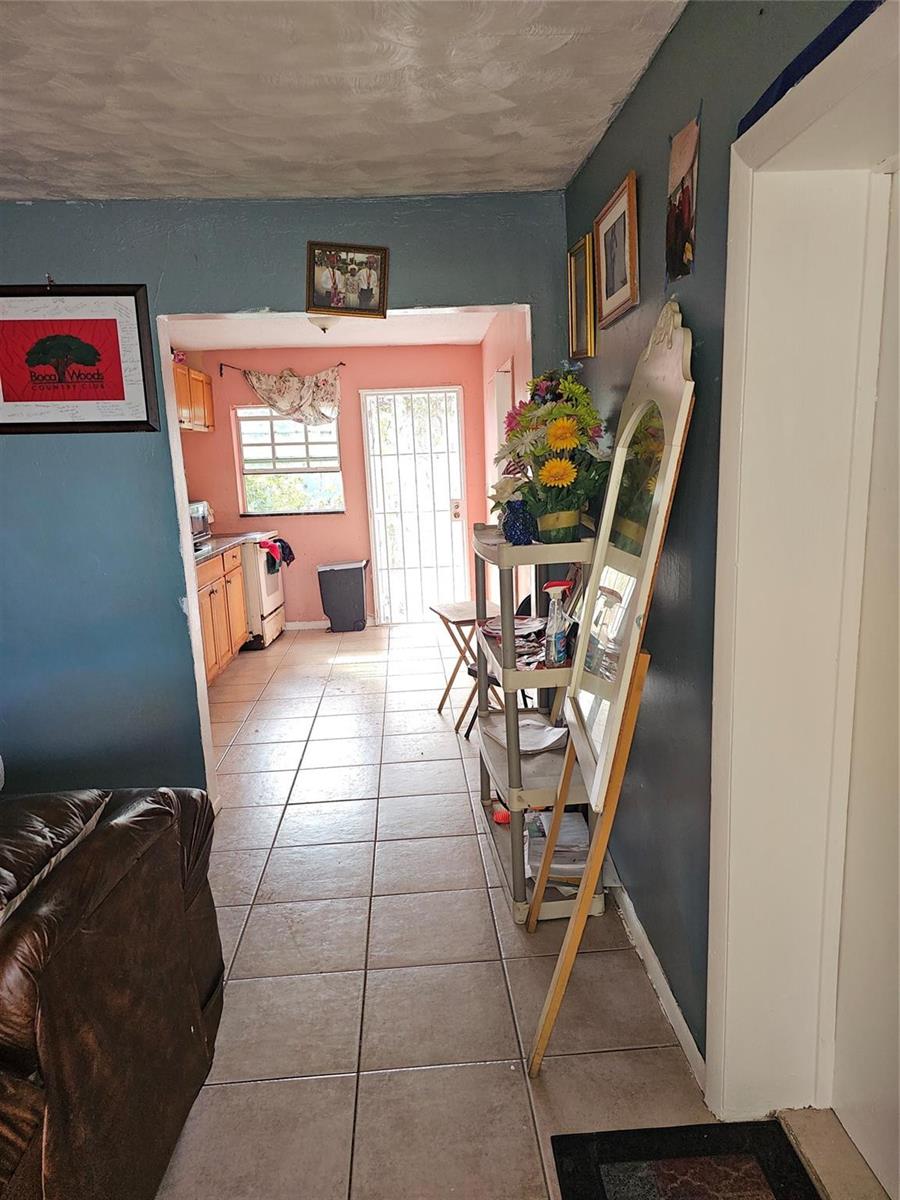 A view from a living area looking into a kitchen with tile floors and a door — 2510 NW 6 Street, Pompano Beach FL 33069, POMPANO BEACH, FL