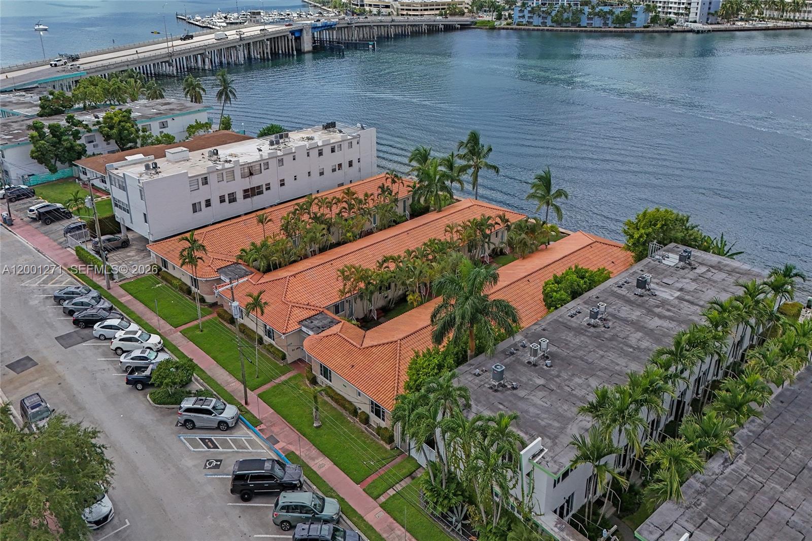 An aerial view shows low-rise apartment buildings with orange tile roofs next to a waterway — 2170 Bay Dr # 20, Miami Beach FL 33141, MIAMI BEACH, FL