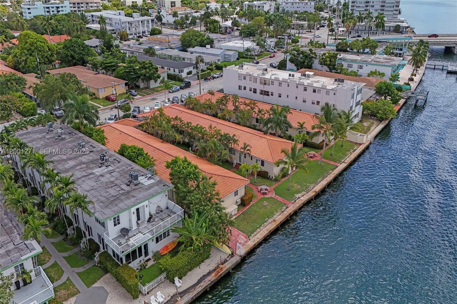 An aerial view shows a multi-unit residential complex with orange-tiled roofs along a waterfront — 2170 Bay Dr # 20, Miami Beach FL 33141, MIAMI BEACH, FL