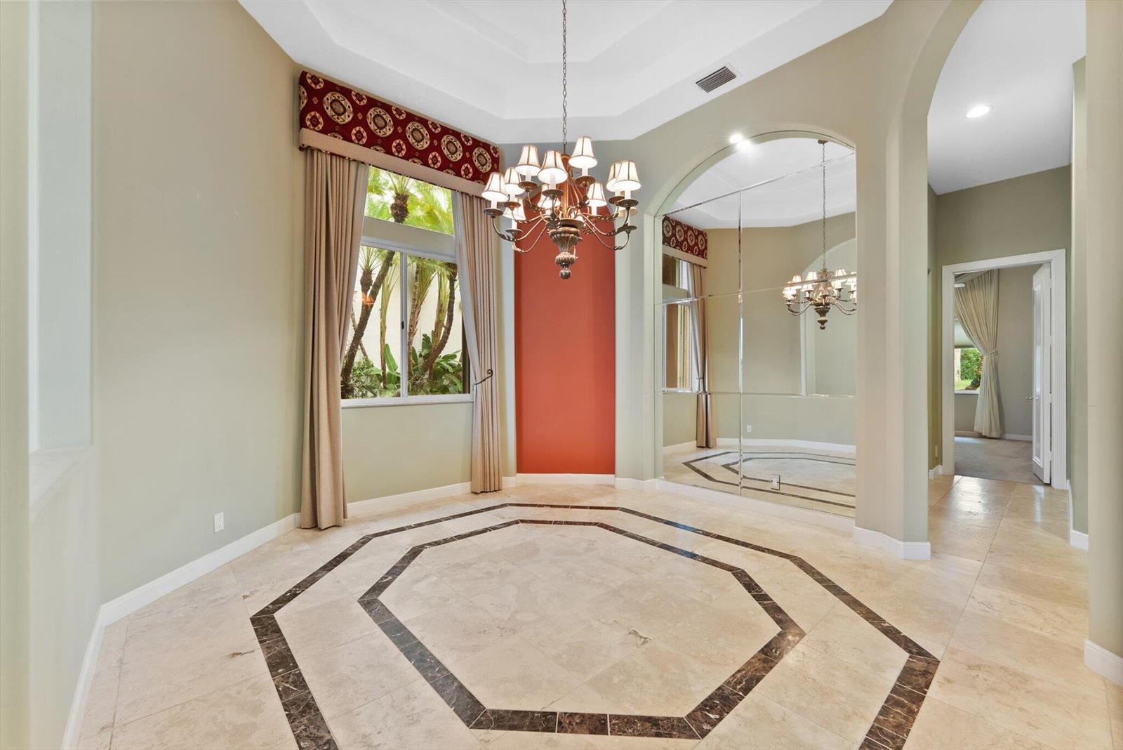 A dining room features a tray ceiling, a chandelier, tiled floors, and a mirrored wall — 7081 Mallorca Crescent, Boca Raton FL 33433, BOCA RATON, FL